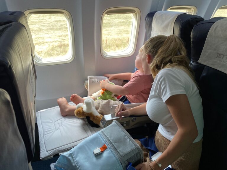 Fliegen mit Kindern: Entspannt ans Ziel Fliegen mit Kindern – Mutter und Kind sitzen zusammen im Flugzeug